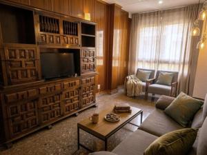 a living room with a couch and a flat screen tv at Casa Centro 48 by Eden Mar - Ideal para estancias temporales in Guardamar del Segura