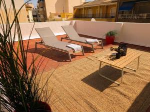 two chairs and a table on a patio at Casa Centro 48 by Eden Mar - Ideal para estancias temporales in Guardamar del Segura