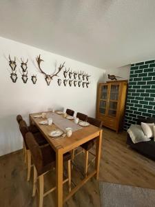 a dining room with a table and some antlers on the wall at Jagdstube in Prezelle +18 photos