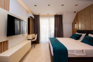 a hotel room with a bed and a flat screen tv at Premium Apartments Zevs in Budva
