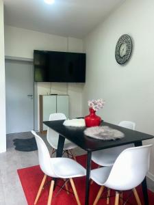 a dining room with a black table and white chairs at Schöne Ferien- und Monteurwohnung in Ennepetal