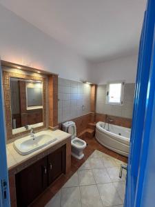 a bathroom with a sink and a tub and a toilet at Choios' House in Kondoliánika +21 photos