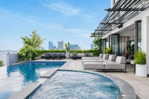 an outdoor patio with a swimming pool and patio furniture at Harmony Phnom Penh Hotel in Phnom Penh