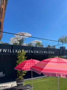 two red umbrellas sitting in front of a sign at Apart & Suiten Hotel WEIDEN in Schladming