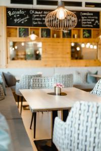 a table and chairs in a restaurant with a chandelier at Apart & Suiten Hotel WEIDEN in Schladming +148 photos