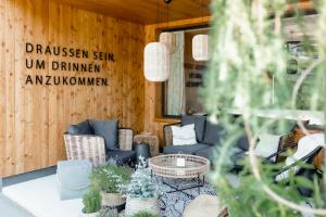 a room with couches and a table and some plants at Apart & Suiten Hotel WEIDEN in Schladming