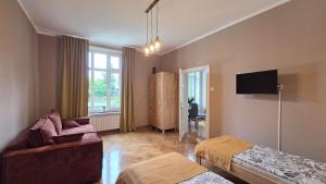 a living room with a couch and a tv at ENKLAWA Apartamenty in Przemyśl