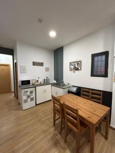 a kitchen and dining room with a wooden table at Hostal Delfos in Barcelona