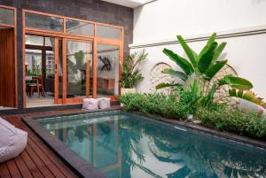 a swimming pool in the middle of a house at Selena Home Tropical Villa Jimbaran in Jimbaran