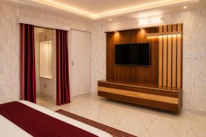 a hotel room with a television and a bed at Jannat Hotel - Solan in Solan