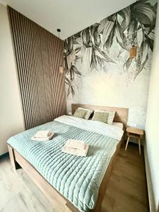 a bedroom with a bed with a painting on the wall at Pełnia Mazur in Pasym