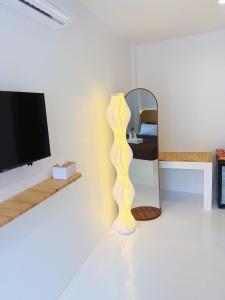 a living room with a yellow floor lamp and a mirror at Albus resort Kohlarn in Ko Larn