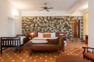a bedroom with a bed and a couch in it at By The Bay Kovalam in Trivandrum +81 photos