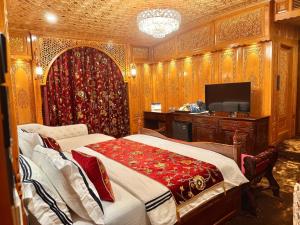 a bedroom with a bed and a tv in it at Suroor Houseboat in Srinagar