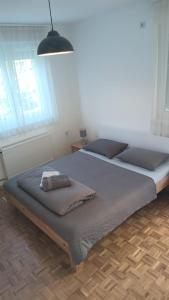 a bedroom with two beds and a pendant light at Apartment SAYA in Banja Luka