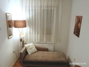 a living room with a couch in front of a window at Apartment SAYA in Banja Luka