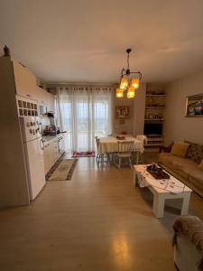 a kitchen and living room with a table and a white refrigerator at Lake View Apartment in Pogradec