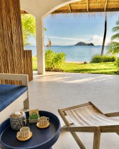 a living room with a table and a view of the ocean at Baan Jai Dee Beach Front Hotel in Wok Tum