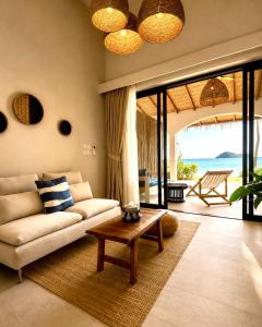 a living room with a couch and a table at Baan Jai Dee Beach Front Hotel in Wok Tum