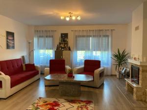 a living room with a red couch and a table at Casa Poarta Paradisului in Moldoveneşti +12 photos