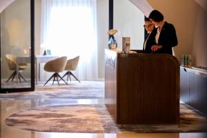 two people standing at a reception desk at Maison Pic in Valence +39 photos
