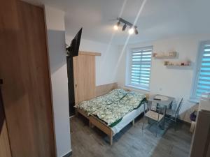a small bedroom with a bed and a table at u Oli Dawid Spaczyński in Mrzeżyno