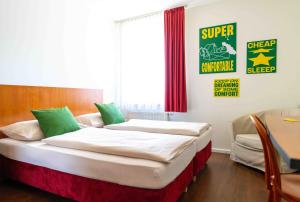 a bedroom with two beds and a sign on the wall at SLEEEP Hotel Sattledt in Sattledt