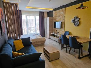 a living room with a blue couch and a bedroom at Sunset S12 Milmari in Raška