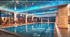 a large swimming pool with chairs in a building at Sunset S12 Milmari in Raška