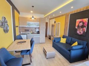 a living room with a blue couch and a table at Sunset S12 Milmari in Raška