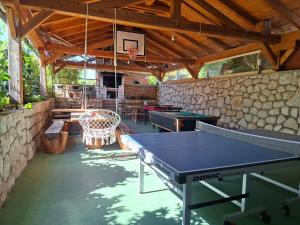 a ping pong table in a room with a stone wall at San Lorenzo in Lopar