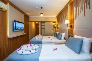 a hotel room with two beds and a tv at Caria Special Class in Dalyan