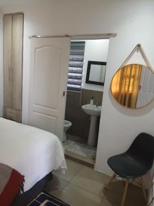 a bedroom with a bed and a chair and a sink at Russell's Rest Apartments in Johannesburg +31 photos