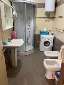 a bathroom with a shower sink and a washing machine at Lake View Apartment in Pogradec +33 photos