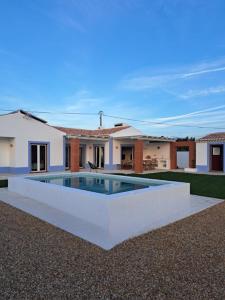 a house with a swimming pool in front of it at Casa dos Foros in Odemira