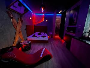 a room with a bed and a red room with a couch at Magik Love Apartament in Piła