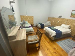 a room with two beds and a vanity with a mirror at Keetmanshoop Self-catering in Keetmanshoop