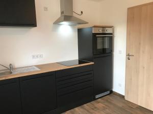 a kitchen with black cabinets and a black refrigerator at Wohnung Regina in Wildenfels +3 photos