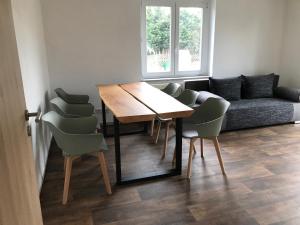 a living room with a wooden table and chairs at Wohnung Regina in Wildenfels