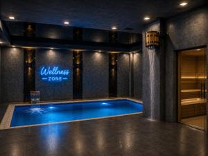 a swimming pool in a building with a sign on the wall at The Wood Hotel & Spa near Magic City in Tashkent