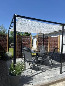 a patio with a table and chairs under a canopy at Kleine Hafenperle in Varel