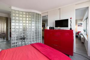 a red bedroom with a red dresser and a tv at L'Horizon by Cocoonr in Rennes