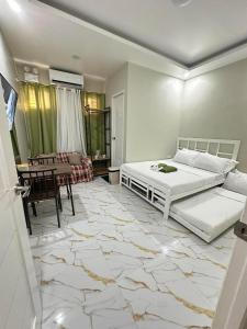 a bedroom with a bed and a table and a dining room at Green Meadows Residence Naga in Milaor
