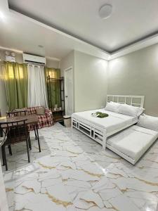 a bedroom with a bed and a dining room at Green Meadows Residence Naga in Milaor