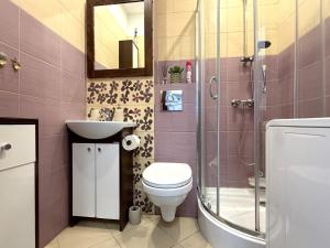 a bathroom with a toilet and a sink and a shower at Apartament Solankowa Róża in Inowrocław
