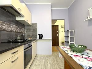 a kitchen with white cabinets and a wooden table at Apartament Solankowa Róża in Inowrocław