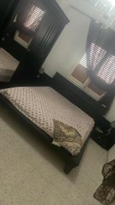 a small bed in a room with two windows at Gharbi in Bizerte