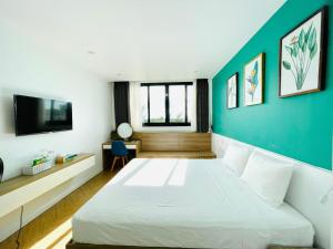 a bedroom with a white bed and a blue wall at The Track Homestay - Near Bai Dai Beach in Cam Lâm +21 photos