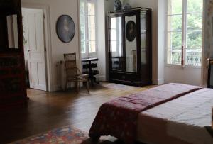 a bedroom with a bed and a dresser and windows at Chambre d'hôtes chez Johannes et Adèle in Brive-la-Gaillarde +18 photos