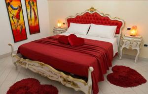 a bedroom with a large red bed with two red pillows at La casa degli amanti con Jacuzzi in Pontinia